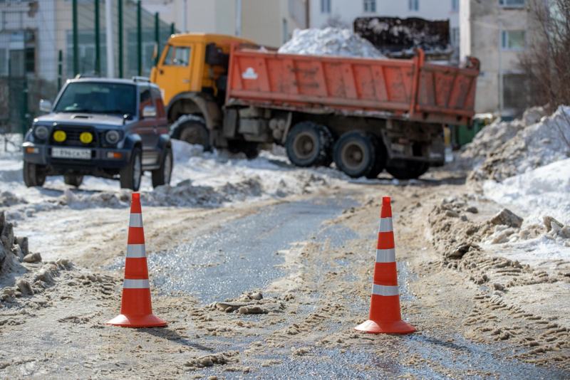 Orange traffic cones on a snowy work zone